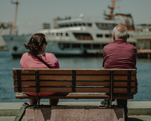 Older man and women on the bench near to the sea side