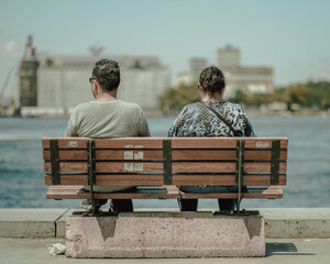 Couple sitting on the bench near to the sea side