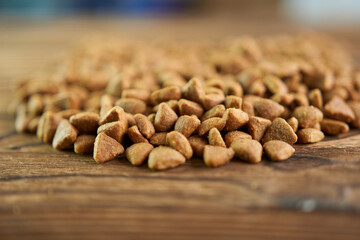 Dry cat food on a wooden background. Food for pets.