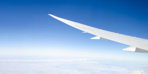 white wing of an airplane against clear blue sky, clouds. Template, banner design. concept of travel