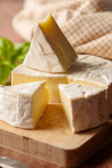 Close up Brie, soft cheese slices on cutting board. Copy space