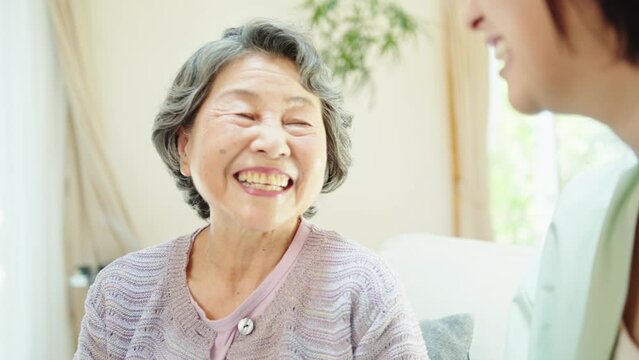 リビングで孫と話すシニア女性