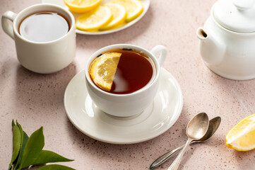 Drinking tea, white ceramic cup of black tea and lemon slice. Slow living. 