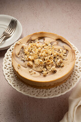 Whole caramel cheesecake served with cup of tea, top view. 