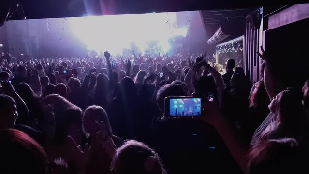 people with smartphones. Silhouettes. People taking videos and photos on a smartphone at a concert.