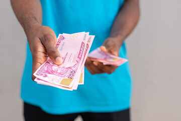 a nigerian man giving someone money
