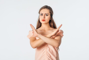 Stop it. Serious young woman shows stop, enough gesture, makes cross sign and denies smth,...