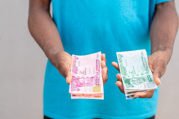 man holding the new nigerian naira notes