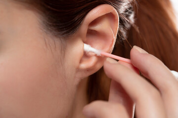 Obraz premium Young woman cleaning ear with cotton swab , closeup