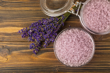 Fototapeta na wymiar Sea salt with lavender flowers in a bowl on a brown textural background. Bath salt with lavender extract and aroma. Beauty spa treatments. Skin care concept.