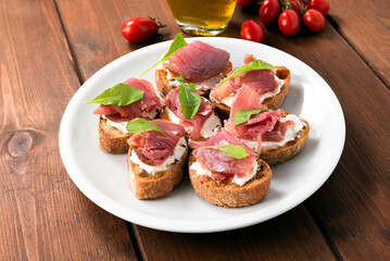 Piatto con deliziosi crostini farciti con tonno fresco e crema di formaggio, antipasti italiani 