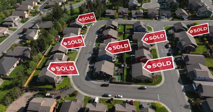Drone shot of SOLD signs popping up over recently sold houses in a suburban neighborhood.