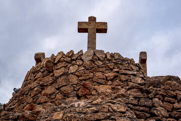 Sstone cross at Parc Guell in Barcelona. Three Crosses Hill at the top of Park Guell by Antoni Gaudi.