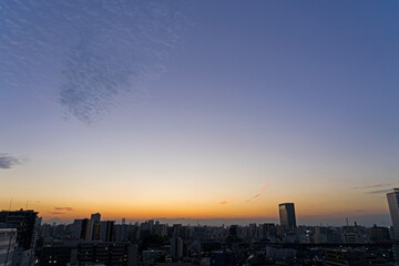 Naklejka premium ウロコ雲と夕焼けの街