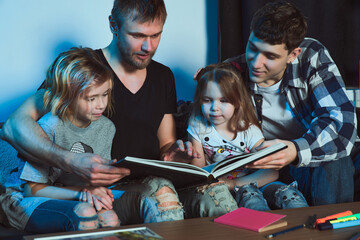 Staged photo. Homosexual couple and their children, two  girls, at home. The whole family gathered...