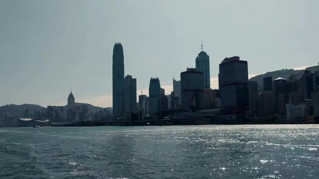 Silhouette of Hong Kong island skyline during the day, view from boat on Victoria Harbor