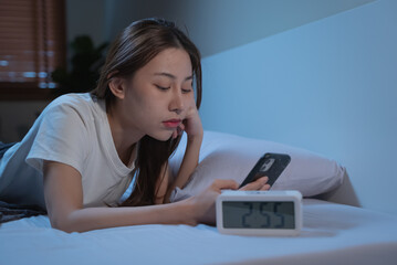 Asian women opened eyes lying on the bed have an insomnia problems.