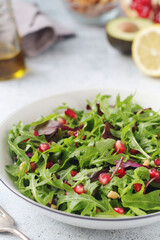 A plate with green rocket salad with pomegranate