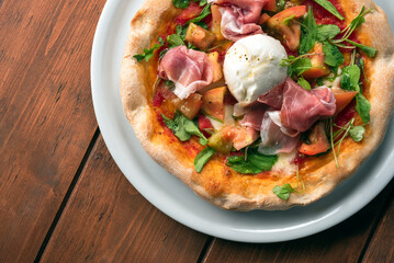 Deliziosa pizza condita con pomodoro fresco, mozzarella di bufala, rucola e prosciutto crudo, cibo italiano