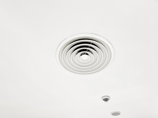 Fototapeta na wymiar Ceiling mounted cassette type air conditioner and modern lamp light on white ceiling. duct air conditioner for home or office