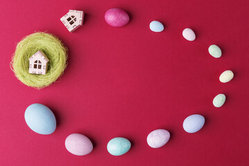 Fototapeta premium Painted Easter eggs and decorations located in shape of egg on viva magenta background with copy space