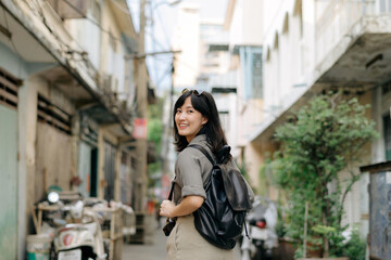 Fototapeta na wymiar Young Asian woman backpack traveler enjoying street cultural local place and smile. Traveler checking out side streets.
