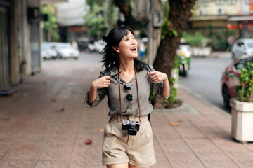 Young Asian woman backpack traveler enjoying street cultural local place and smile. Traveler checking out side streets.