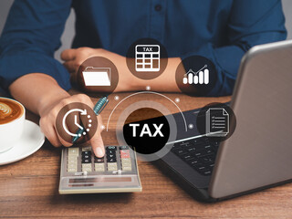Businessman using a calculator to calculate tax while sitting in the office