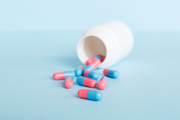 plastic medicine bottle with capsules of pills on colored background. Online pharmacy. Painkiller medicine and antibiotic drug resistance concept. Pharmaceutical industry
