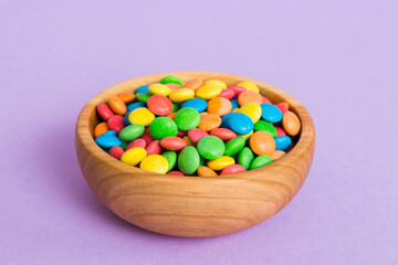 Multicolored candies in a bowl on a colored background. birthday and holiday concept. Top view with copy space