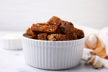 Crispy rusks with sauce on white marble table