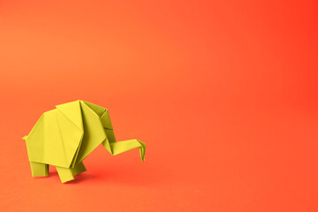 Origami art. Beautiful paper elephant on orange background, space for text