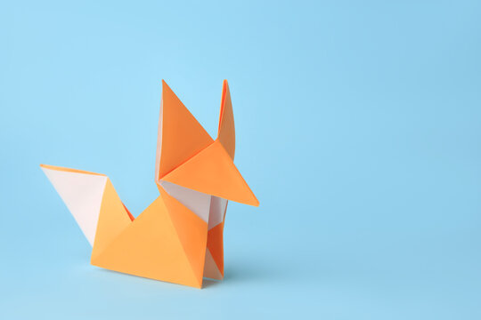 Origami Art. Handmade Orange Paper Fox On Light Blue Background, Space For Text