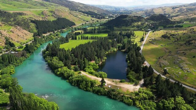 Tranquil Camping Area At Pinders Pond On The Banks Of Clutha River In Roxburgh, New Zealand. aerial pullback