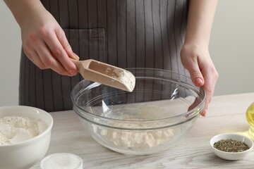 Woman making dough for traditional grissini at white wooden table indoors, closeup