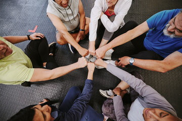 Fist bump, fitness and people n gym training group, circle and community support teamwork for workout. Exercise club, goals and lose weight challenge of friends with collaboration emoji hands above