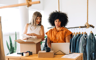 Clothing store owners preparing clothing parcels for shipping