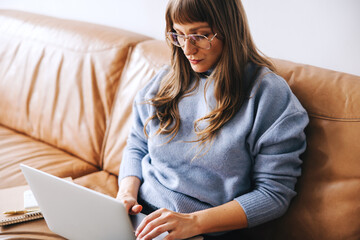 Focused businesswoman working on a laptop in an office lobby