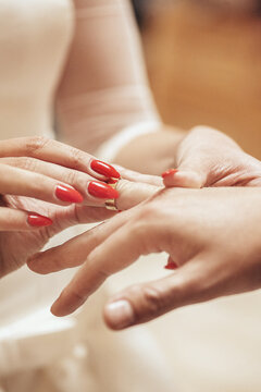 Dłonie Panny Młodej zakładające obrączkę Panu Młodemu