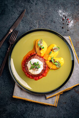 Beef tenderloin cutlet with buratta cheese and pumpkin puree on a green plate. A dish of minced meat steak served on the table