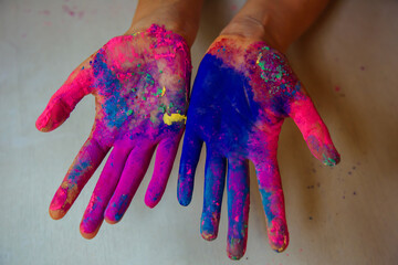 Women's palms covered with bright dry Holi paint. Hands covered in dry paint