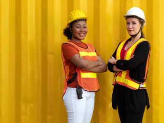 Multiethnic people working together at container yard. Female African American foreman and logistic manager woman standing discussing cargo delivery. Diversity business people teamwork concept