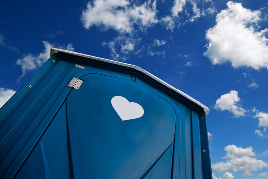 Dixi Toilette mit Herz vor blauem Himmel
