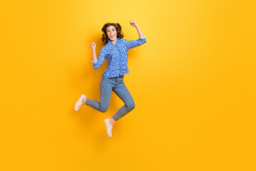 Fototapeta na wymiar Full length portrait of overjoyed energetic person jumping raise fists celebrate isolated on yellow color background