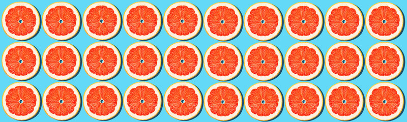Grapefruit rings on a blue background. Bright juicy background. Concept.