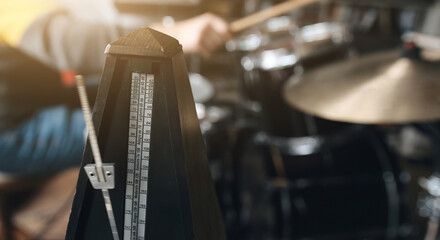 Man playing on drums and bronze cymbal plates with drumsticks in recording studio. Musician during percussion musical instrument perfomance indoors