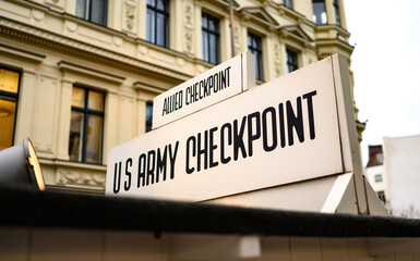 Signpost at Checkpoint Charlie. The crossing point between East and west Berlin, symbol of the Cold War. - obrazy, fototapety, plakaty