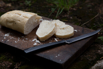 A piece of wheat bread for breakfast cut on a wooden board and a knife