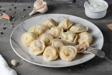 Fototapeta na wymiar Traditional russian pelmeni, ravioli, dumplings with meat on a wooden table