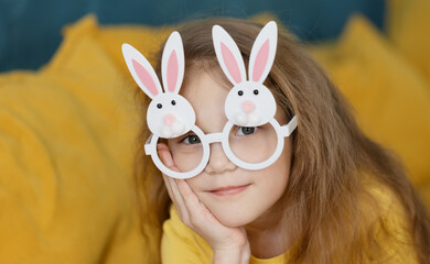 Cute little child girl wearing bunny ears glasses a on Easter day. Easter girl portrait, funny...